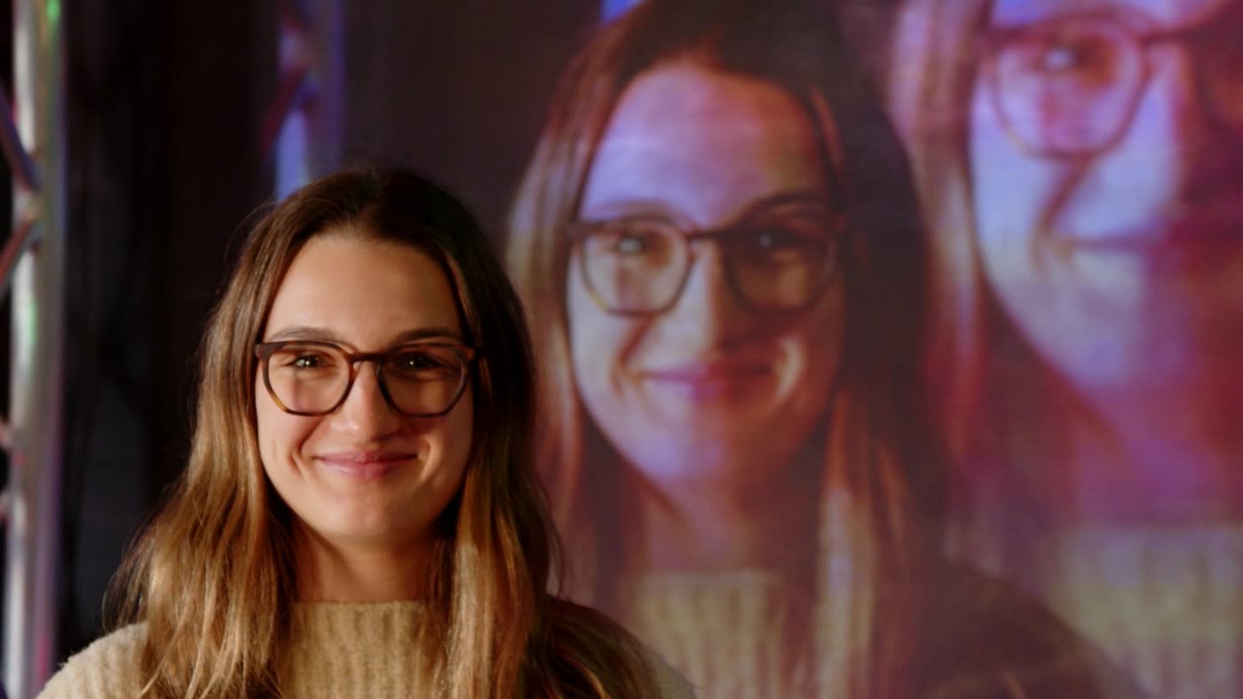 Me smiling in front of a projection showing two larger, delayed copies of myself