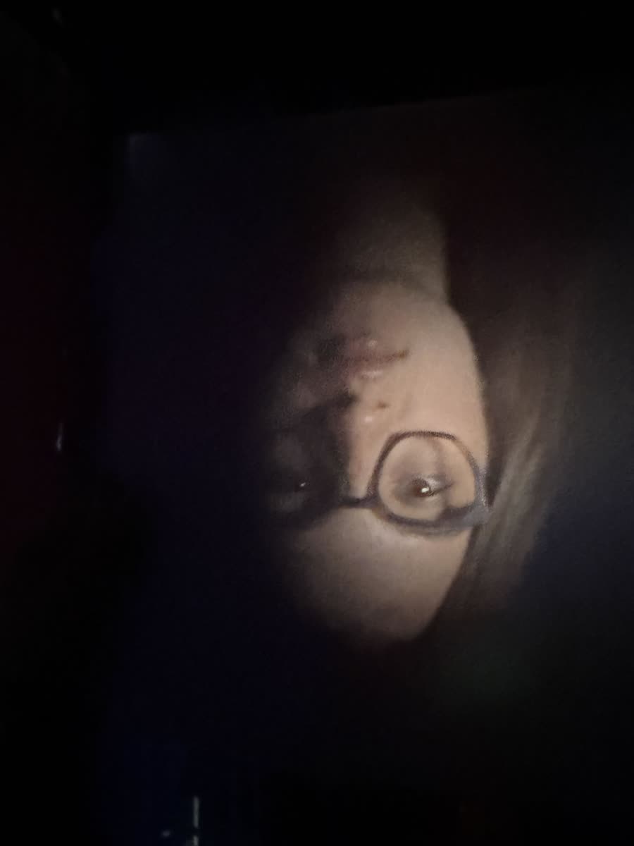 Inverted face, dim with catchlight in glasses