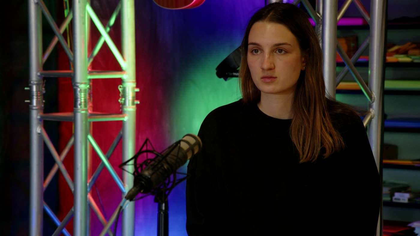 Medium shot, subject on the left third, studio gear on the right